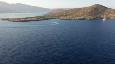 Bir su kayakçısını çeken motorlu teknenin hava görüntüsü. Elounda, Girit, Yunanistan