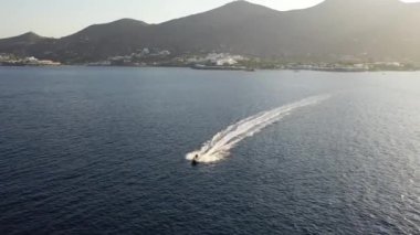 Koyu mavi bir denizde bir jet ski teknesinin hava görüntüsü. Spinalonga Adası, Girit, Yunanistan
