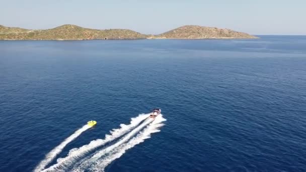 Vue aérienne d'un bateau à moteur remorquant un tube. Elounda, Crète, Grèce 
