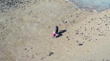 Anne ve küçük kızın kumsalda yürüyüşünün havadan görüntüsü, Whitstable, Kent