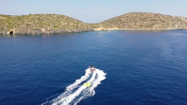 Vue aérienne d'un bateau à moteur remorquant un tube. Elounda, Crète, Grèce 