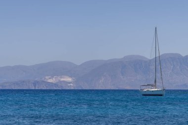 Beyaz yay ve arka planda dağlarla kıyı manzaralı yaz denizi Yunanistan