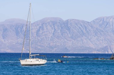 Beyaz yay ve arka planda dağlarla kıyı manzaralı yaz denizi Yunanistan