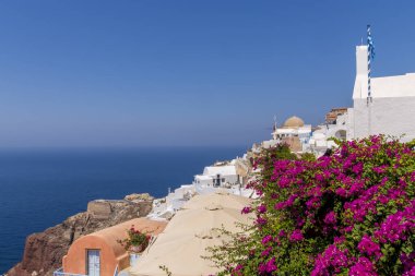 Yunanistan 'ın Santorini adasındaki geleneksel beyaz evleri ve yel değirmenleriyle muhteşem manzaralı Oia köyü.