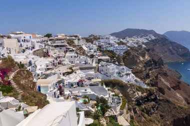 Yunanistan 'ın Santorini adasındaki geleneksel beyaz evleri ve yel değirmenleriyle muhteşem manzaralı Oia köyü.