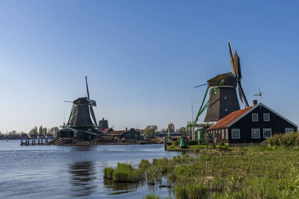 Vista aérea de um velho moinho de vento tradicional holandês na zona rural dos Países Baixos com um dique, canais, ponte e campos . — Fotografia de Stock