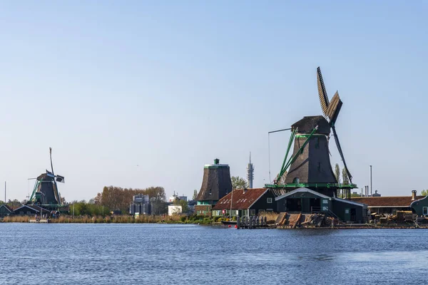 Vista aérea de un antiguo molino de viento tradicional holandés en el campo rural en los Países Bajos con un dique, canales, puente y campos . — Foto de Stock