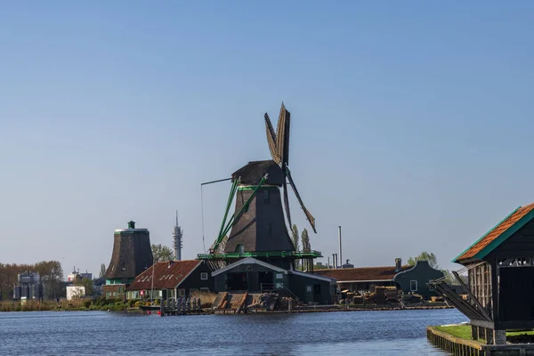 Vista aérea de un antiguo molino de viento tradicional holandés en el campo rural en los Países Bajos con un dique, canales, puente y campos . — Foto de Stock