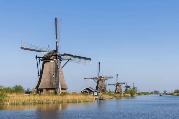 Vista aérea de un antiguo molino de viento tradicional holandés en el campo rural en los Países Bajos con un dique, canales, puente y campos . — Foto de Stock