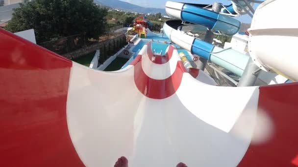 Han har kul i Aqua Park. Han glider ner från attraktionen i slow motion. Thera är mycket stänk väcka honom, Kreta, Grekland — Stockvideo