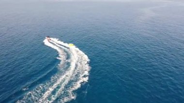 Motorlu bir teknenin tüpü çektiği hava görüntüsü. Elounda, Girit, Yunanistan