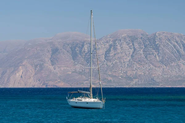 Beyaz yay ve arka planda dağlarla kıyı manzaralı yaz denizi Yunanistan