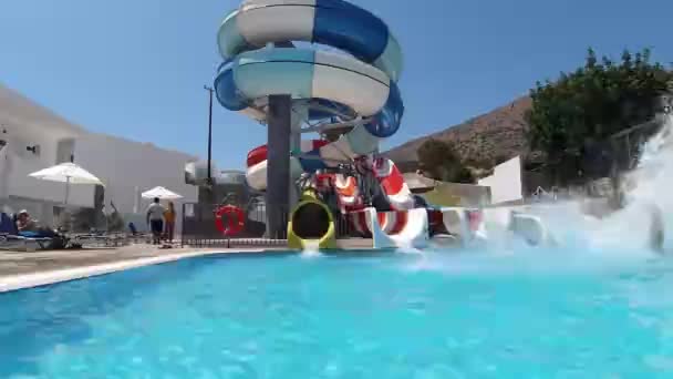 Han har kul i Aqua Park. Han glider ner från attraktionen. Thera är mycket stänk väcka honom, Kreta, Grekland — Stockvideo