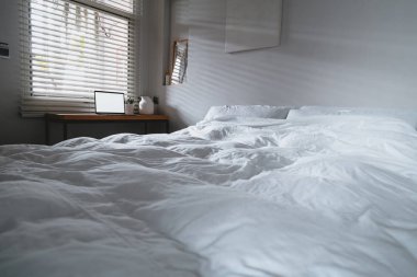 Boş ekranı kopyalayan dizüstü bilgisayar ve beyaz sayfalı yatak