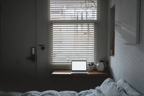 Portátil con espacio de copia pantalla vacía y cama con sábanas blancas —  Fotos de Stock