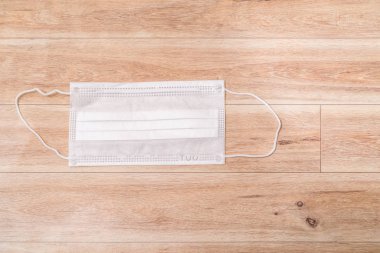 Ahşap masa arkasında koruyucu tıbbi maske.