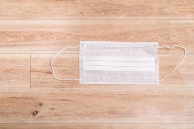 Ahşap masa arkasında koruyucu tıbbi maske.