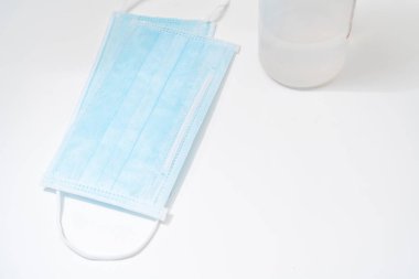 Beyaz zemin üzerinde koruyucu yüz maskesi ve dezenfektan jel dağıtıcısı, Novel coronavirus (2019-ncov) veya Wuhan coronavirus ve Influenza 'ya karşı. Antiseptik, Hijyen ve Sağlık Konsepti