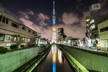 TOKYO, JAPONYAN - 28 Mar 2019 Tokyo Skytree, Sumida Ward Urban gece sahnesi. Tokyo Skytree kulesi kanala yansıyor.