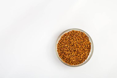 Karabuğday beyaz arka planda bir tabakta inliyor. Küçük bir tabakta karabuğday lapası. Diyet kahvaltı. Sağlıklı yemek..