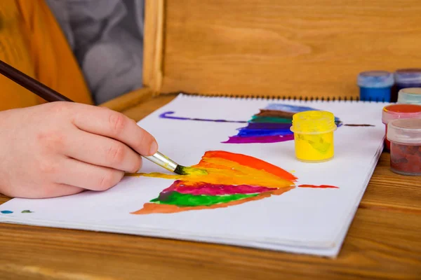 Çocuk suluboya resim yapıyor, resim yapıyor. Çocuk çizimi. Çok renkli olsun. İki şemsiye. Çizim için albüm. Anaokulu ve okul - Stok İmaj