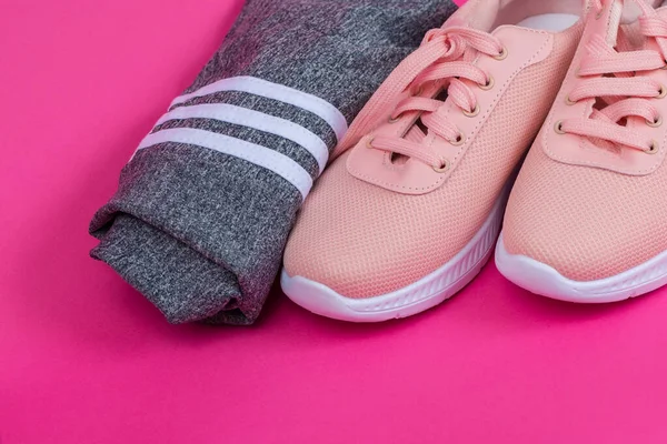 Pink sneakers and shorts on a pink background. Clothes for sports. Weight loss and sports.