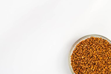 Karabuğday beyaz arka planda bir tabakta inliyor. Küçük bir tabakta karabuğday lapası. Diyet kahvaltı. Sağlıklı yemek..