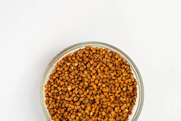 Karabuğday beyaz arka planda bir tabakta inliyor. Karabuğday por