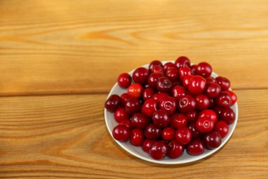 Ahşap arka planda olgun kırmızı kirazlar. Kahverengi arkaplanda kırmızı meyveler.