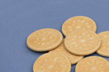 Gri arka planda ince yuvarlak kurabiyeler. Lezzetli ev yapımı kurabiyeler. Masada tereyağlı kurabiye var. Kurabiye..