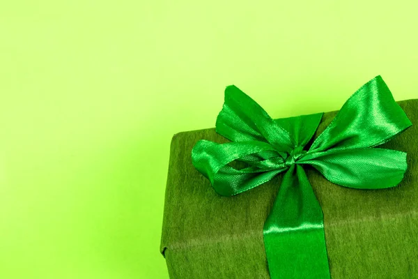 緑の包装で贈り物。緑の背景の男への贈り物だ緑のリボン付き3月8日プレゼント. — ストック写真