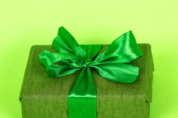 緑の包装で贈り物。緑の背景の男への贈り物だ緑のリボン付き3月8日プレゼント. — ストック写真