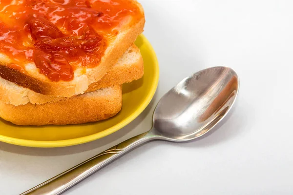 Beyaz arka planda ekmek ve kayısı reçeli. Reçelli tost. Kahvaltıda tatlı. Reçelli ekmek dilimleri. Yüksek kalorili sandviçler