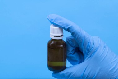 Mavi arka planda el dezenfektanı şişesi. Alkol solüsyonu. Alkol jeli virüsler, bakteriler, grip, koronavirüs, covid-19 için kullanılır. El yıkama.