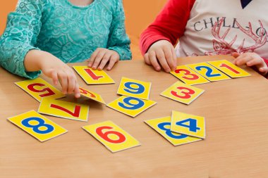 İlkokulda matematik dersi. Çocuklar oynuyor. Eğitici oyunlar. Anaokulunda bir çocuk. Bir çocuğun elleri. Matematik tabletleri