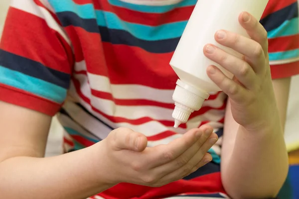 Ellerinde antiseptik olan beyaz bir şişe. Coronavirus profilaksi. Eller antiseptik antibakteriyel jel ile yakın çekim. Ellerini koronirüs virüsünden korumak için jel.