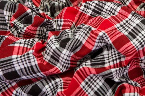 Red checkered fabric. Black and red checkered fabric. Textiles for plaid, tablecloths, clothes, shirts, dresses. A sample of red fabric close-up