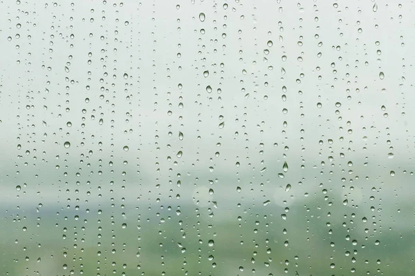 Drops of rain on window in summer day