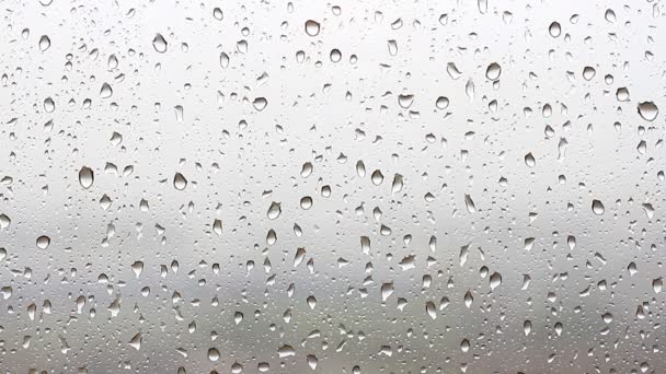 Gotas de lluvia fluyen por el cristal de la ventana — Vídeos de Stock