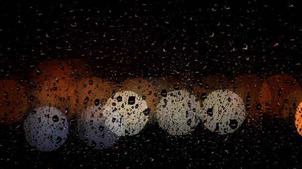 Des gouttes de pluie coulent dans la vitre la nuit — Video