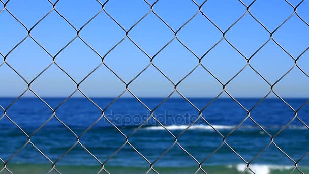 Sea behind steel netting, focus on steel netting — Stock Video