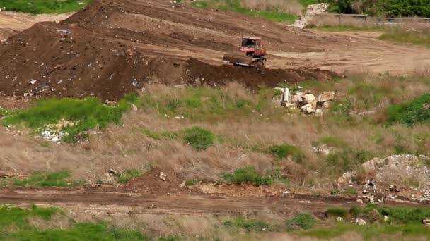 Bulldozer herverdeling van de aarde op een aarden Dijk — Stockvideo