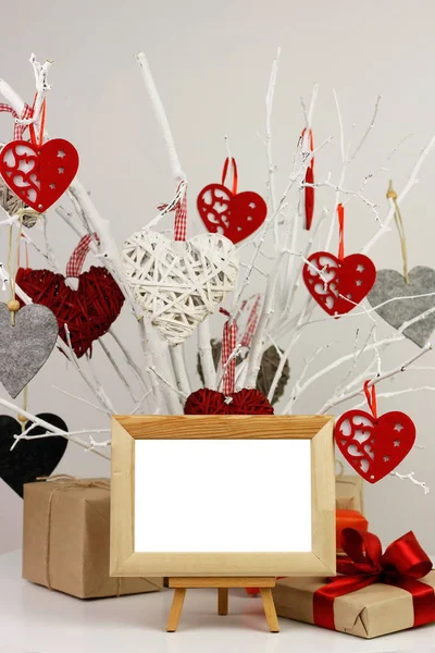Blank photo frame and gifts on background of tree with valentines — Stock Photo, Image