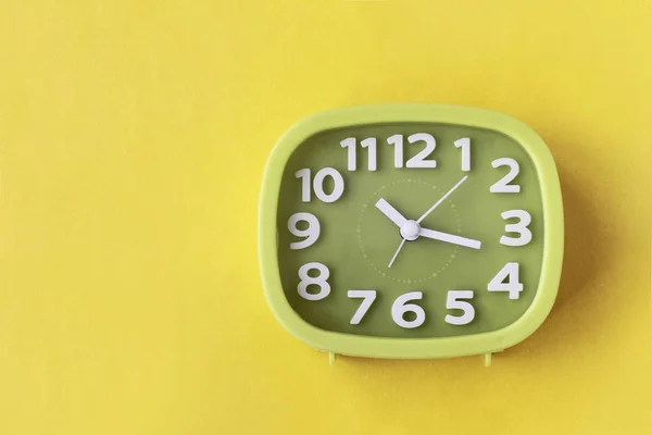 Grüne Uhr Mit Weißen Zahlen Und Pfeilen Auf Gelbem Hintergrund — Stockfoto