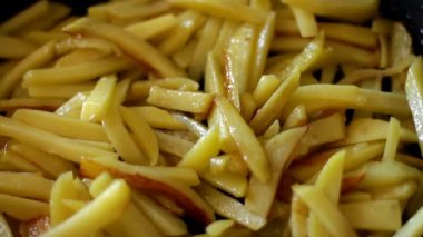 Kızartma tavasında patates kızartması dilimleri ve ev mutfağında pişirme yağı ve tuz hazırlama yemeği. Kapatın. Seçici odaklanma. Kavram - sağlıksız yemek, fast food