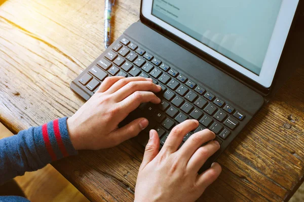 Young student types on a computer during home school while quarantined - Pandemic - Stay at Home - Concept Education - Indoors