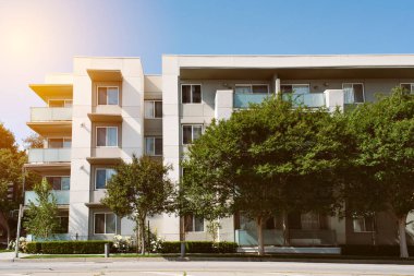 Bir banliyö ortamında ağaçları olan daha yeni bir çok aile apartmanı - Güneşli Gün - Gayrimenkul