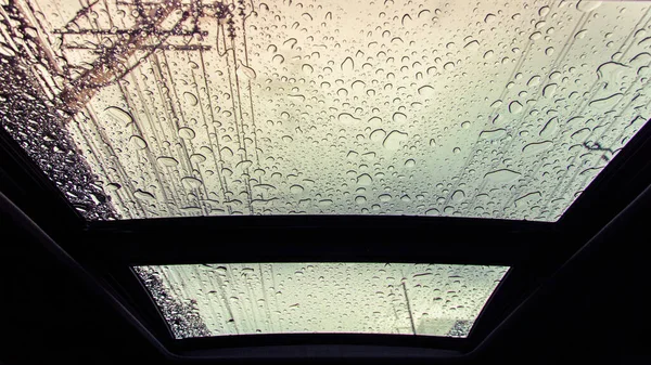 Water drops on glass of car sunroof with copy space.