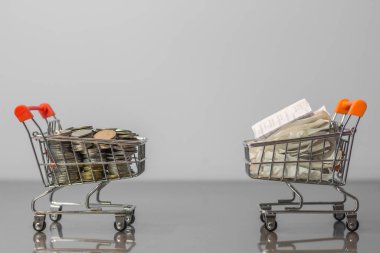 Bozuk paraları ve makbuzları beyaz arka plandaki mini alışveriş arabasının üzerine kapat (İş ve Finans kavramı)