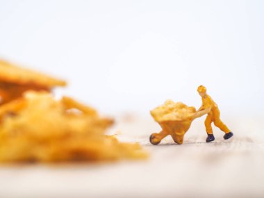 Minyatür insanlar, işçiler beyaz arka planda patates cipsi üretimi üzerinde çalışırlar (gıda konsepti)